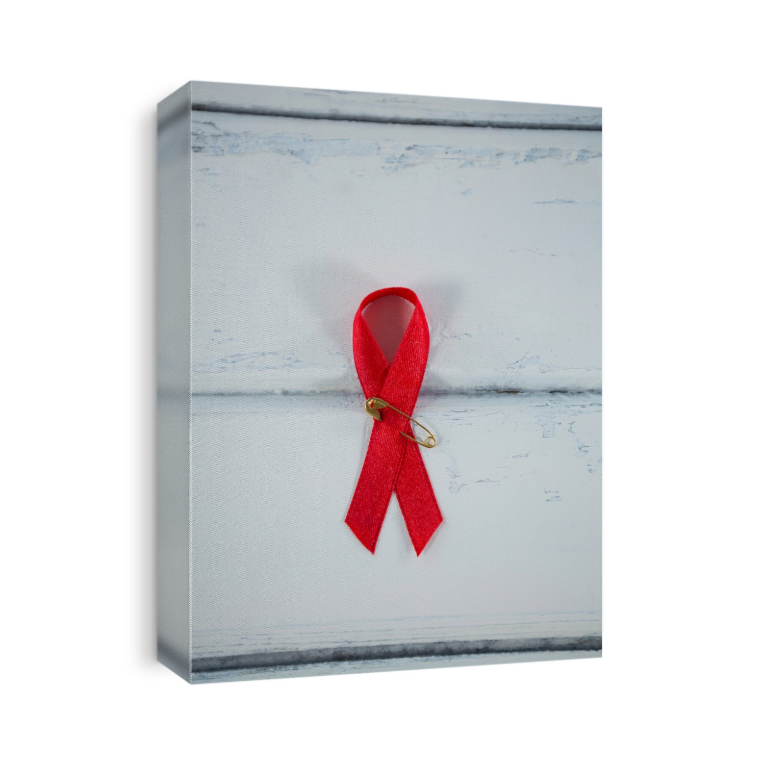 Overhead view of red AIDS awareness ribbon on white wooden table